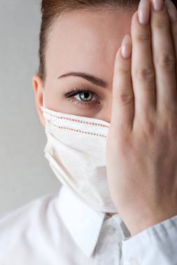 Tıbbi maskeli bir kızın portresi. Elimle yüzümün bir yarısını kapatacağım. Kapat şunu.