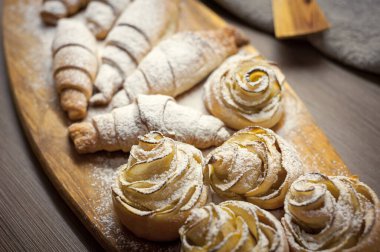 Lezzetli kruvasanlardan ve elmalı pastalardan oluşan bir kafenin ahşap tahtasına yakın.