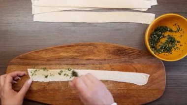 Kadın eli dolguyu şişirmek için sarar. Bitki ve sarımsak. Yukarıdan görünüşü