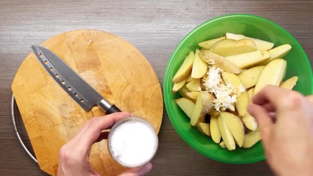 L'homme mélange soigneusement les pommes de terre crues. Assaisonné de sel et de poivre. La vue du haut . — Video