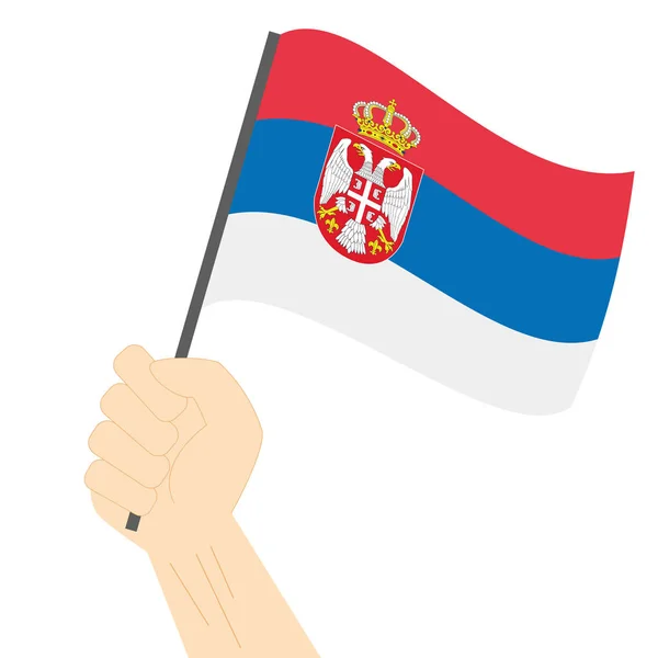 Mão segurando e levantando a bandeira nacional da Sérvia — Vetor de Stock