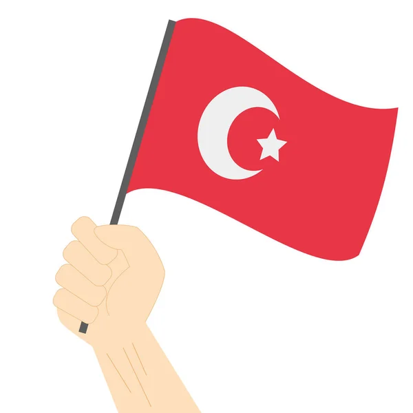 Mão segurando e levantando a bandeira nacional da Turquia — Vetor de Stock