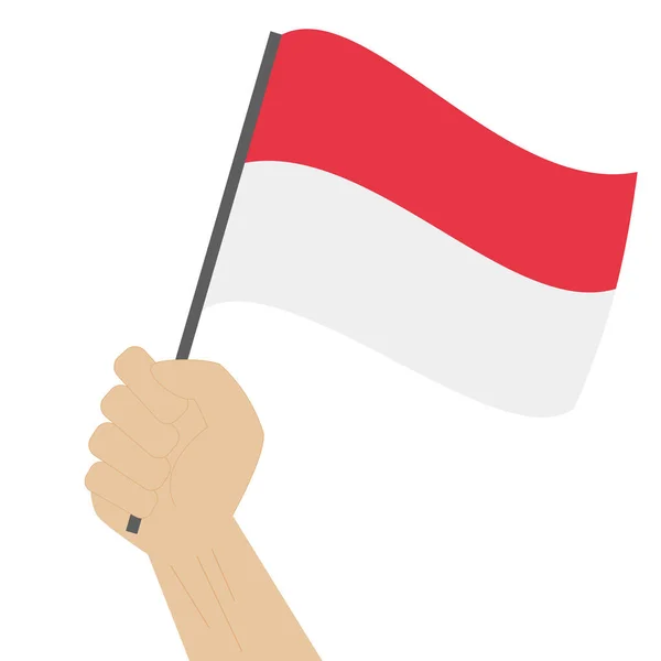 Hand holding and raising the national flag of Indonesia — Stock Vector