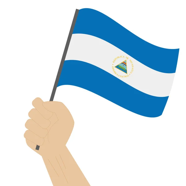 Mão segurando e levantando a bandeira nacional da Nicarágua —  Vetores de Stock