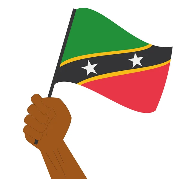 Hand holding en verhoging van de nationale vlag van Saint Kitts en Nevis — Stockvector