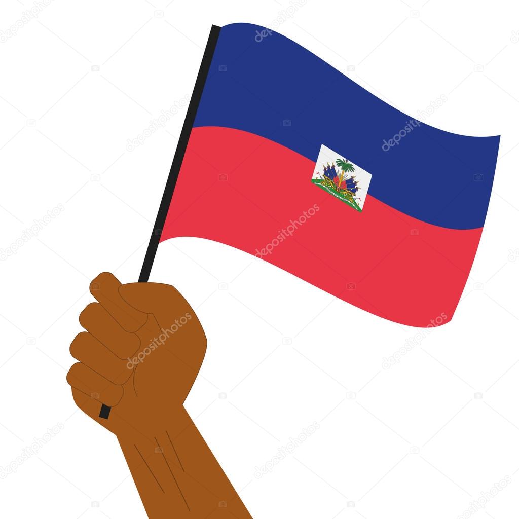 Hand holding and raising the national flag of Haiti