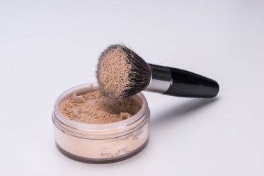 Makyaj tozu ve fırça beyaza izole edilmiş.