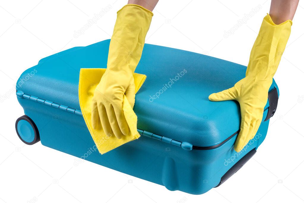 Hands in yellow rubber gloves clean turquoise plastic suitcase with the yellow microfiber cloth.