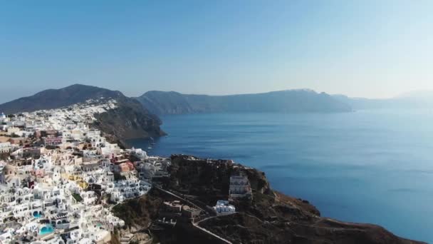 Voando sobre a famosa igreja cúpula azul em Oia na ilha de Santorini, na Grécia — Vídeo de Stock
