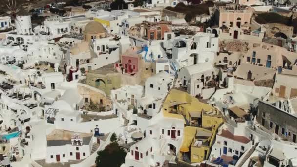 Volando sobre la famosa iglesia con cúpula azul en Oia en la isla de Santorini en Grecia — Vídeos de Stock