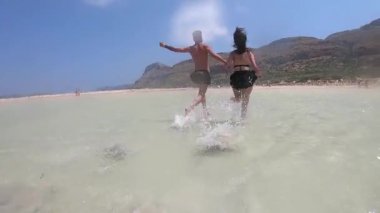 Denize koşan gençler. Mutlu Adam ve Kadın Sahilde Yüzüyor