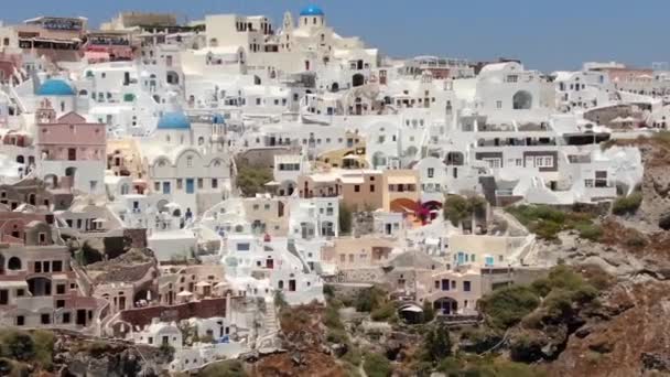 Vlucht rond de Three Blue Domes kerk in Oia stad op Santorini eiland, Griekenland — Stockvideo