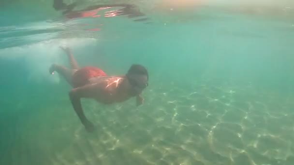 Slow Motion View: Man Jumps Into The Sea With Sunrays Illuminating Him — Stock Video