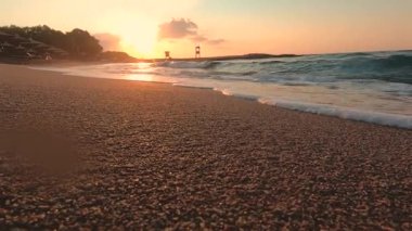 Sessiz deniz dalgalar kıyıya günbatımında yıkama