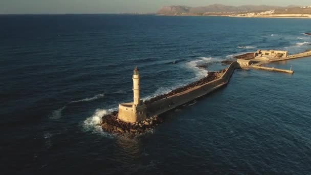 Faro histórico de Chania en la isla de Creta en Grecia con viento que sopla el agua azul del mar Mediterráneo en un día soleado — Vídeo de stock