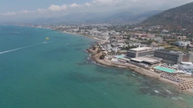 Kumsalda ve mavi denizde hava manzarası. İnsanlar yüzüyor, hayattan ve yaz tatillerinden zevk alıyor, Girit, Yunanistan