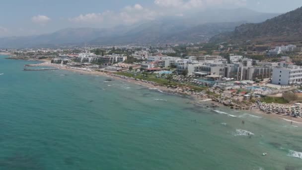 Panorama aéreo na praia e mar azul. As pessoas nadam, desfrutar da vida e férias de verão, Creta, Grécia — Vídeo de Stock