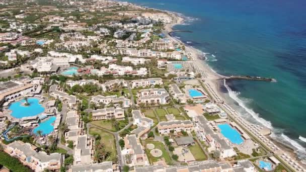 Drohnenantenne von Anissaras Küste in der Nähe von Hersonissos auf der berühmten historischen Betoninsel Griechenland mit Hotelpoolstränden und mediterranen Meereswellen — Stockvideo