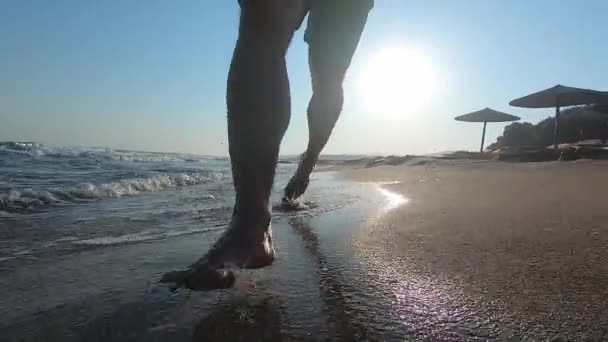 Egy férfi cipőben szaladgál egy Sandy Beach-en a tenger mellett. Lassú mozgás, — Stock videók