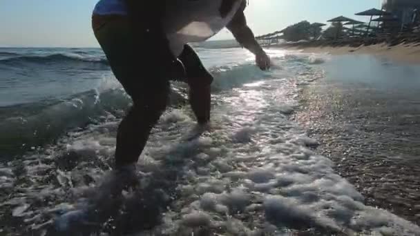 Sportlicher Mann turnt frühmorgens auf dem Meer — Stockvideo