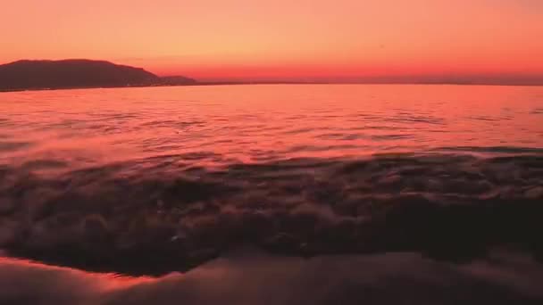 Tidlig morgen soloppgang på en sandbar i havet i Florida.Vakker utsikt over Østersjøbukta ved solnedgang, skyfri himmel i horisonten, oransje solbriller i avstand og et fredelig hav – stockvideo