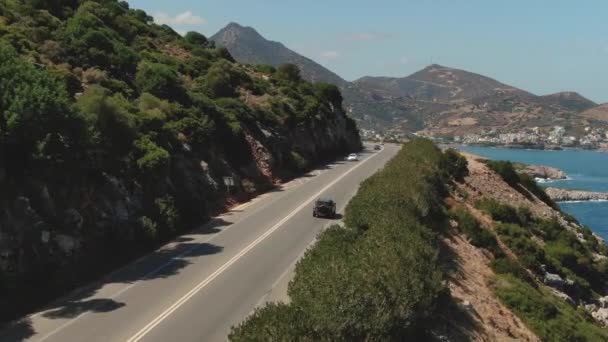 Vista aérea superior de uma movimentação vermelha do carro na estrada perto do mar. Drone aéreo tiro de carros dirigindo na praia e costa rooad . — Vídeo de Stock