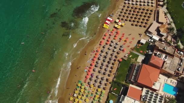 Luftaufnahme von oben, fliegen über den Sandstrand von azurblauen Menschen sonnen sich auf Handtüchern und spielen im grünen Wasser — Stockvideo