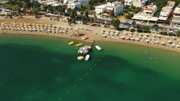 Top uitzicht vanuit de lucht, vliegen boven het zandstrand van Azure Mensen zonnebaden op handdoeken en spelen in groen water. — Stockvideo
