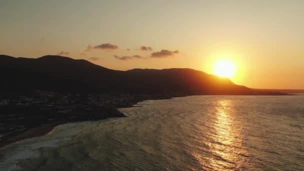 日没時の岩の上のビーチと海の夕日の空中ドローンビデオ、スローモーション — ストック動画