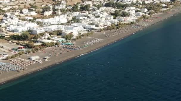 Pláž s slunečníky a lehátky na břehu tyrkysového moře, Řecko Santorini — Stock video