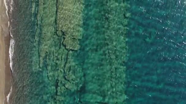 Пляж с зонтиками и лежаками на берегу бирюзового моря, Греция Санторини — стоковое видео
