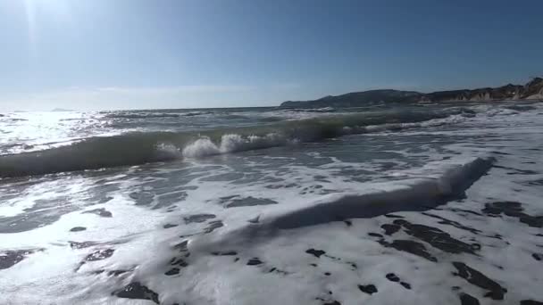 Grandes olas en una playa al atardecer. Hermosas olas de video en cámara lenta en Santorini — Vídeos de Stock