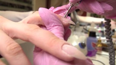 Donanım yakın çekim çekim bir güzellik salonu manikür. Manikürcü parmaklar üzerinde kırpma cuticles için elektrik törpü matkap uyguluyor