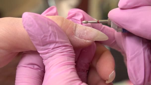 Primer plano de manicura de hardware en un salón de belleza. Manicurista está aplicando taladro de lima de uñas eléctrica para cortar cutículas en dedos femeninos — Vídeo de stock