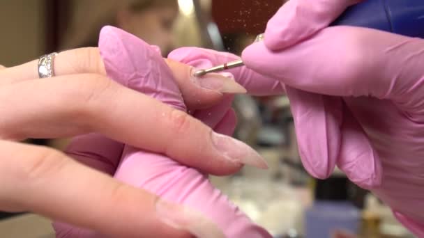 Close-up tiro de manicure hardware em um salão de beleza. Manicure está aplicando broca de arquivo de unhas elétrica para aparar cutículas em dedos femininos — Vídeo de Stock