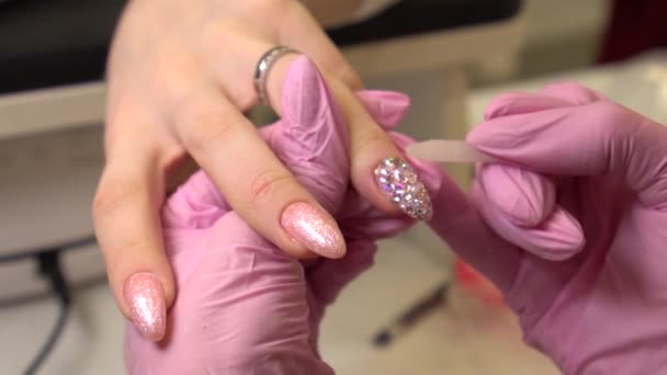 Macro inyectado con manicura que se pega pedrería a las uñas de las mujeres pintadas, maquillaje y uñas, primer plano de la aplicación de esmalte de uñas — Vídeo de stock