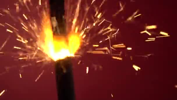 Een sterretje brandt tegen een rode achtergrond — Stockvideo