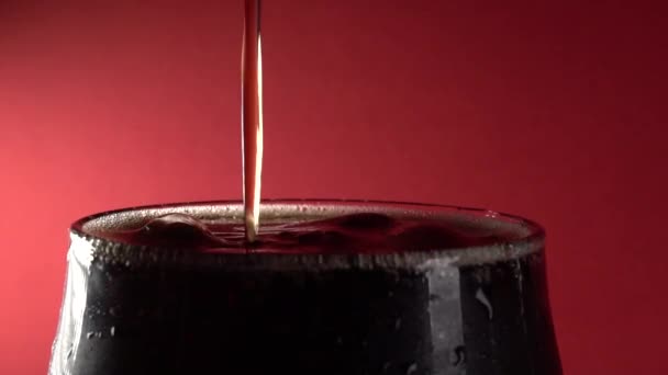 Zeitlupe Close-up Cola in Glas auf rotem Hintergrund gießen — Stockvideo