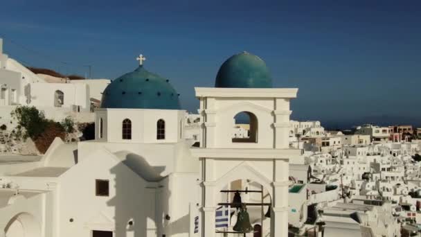 Filmación aérea - Casas blancas y cúpulas azules Iglesia ortodoxa griega, Santorini — Vídeos de Stock