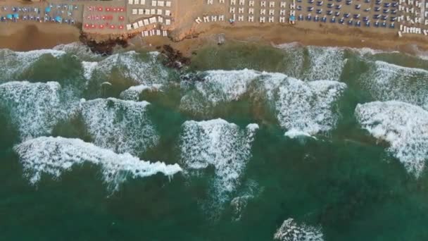 Top uitzicht vanuit de lucht, vliegen boven het zandstrand van Azure Mensen zonnebaden op handdoeken en spelen in groen water. — Stockvideo