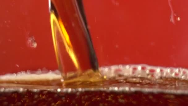 慢动作在红色的背景上闪烁着气泡. 可乐装在杯子里 — 图库视频影像