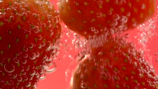 Červená jahoda krásně do vody s bublinkami. — Stock video