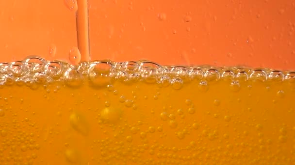 Close-up van de achtergrond van gieten soda water met bubbles, mousserende wijn, champagne of bier in glas, lage hoek zijaanzicht, slow-motion — Stockvideo