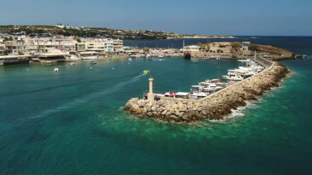 Vista aérea del faro y del puerto veneciano antiguo de la ciudad de Hersonissos en la costa norte de la isla de Creta, tiro aéreo — Vídeo de stock