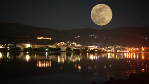 Volle maan boven het dorp Opkomend reflecterend op het oppervlak van het water. Griekenland — Stockvideo