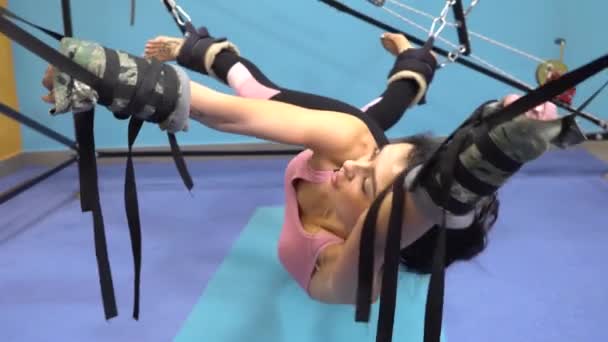 Pilates vrouw in Cadillac split benen strekken oefening bij het rekken op de simulator REGEL — Stockvideo