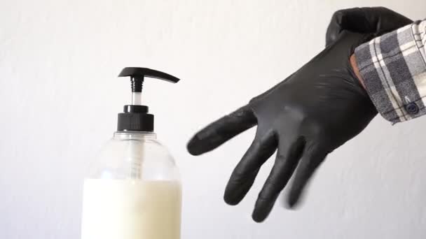 Мыть руки с мыльщиком для профилактики коронных вирусов. Руки, надевающие защитные черные перчатки. Латексные перчатки как символ защиты от вирусов и бактерий. — стоковое видео