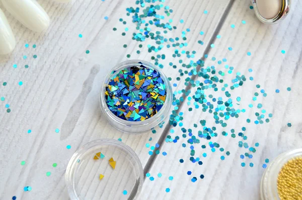 blue glitter for nail design on a wooden table