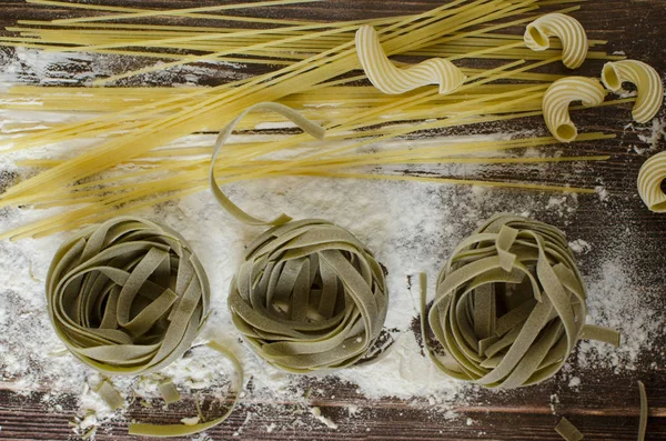 Αμαγείρευτα Ζυμαρικά Ένα Ξύλινο Τραπέζι Οποία Είναι Πασπαλισμένα Αλεύρι — Φωτογραφία Αρχείου