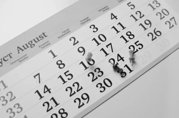 Black and white monthly calendar on table with office supplies — 스톡 사진